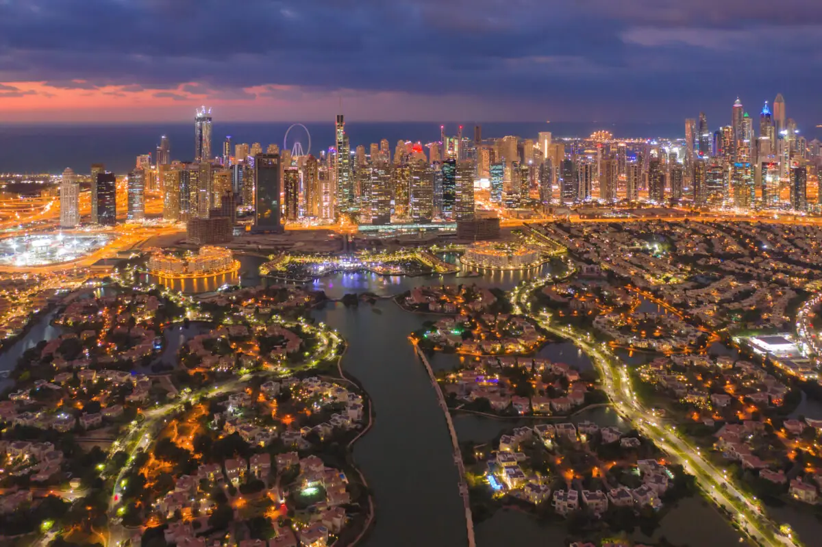 Dubai Marina skyline at dusk above lakeside villa communities
